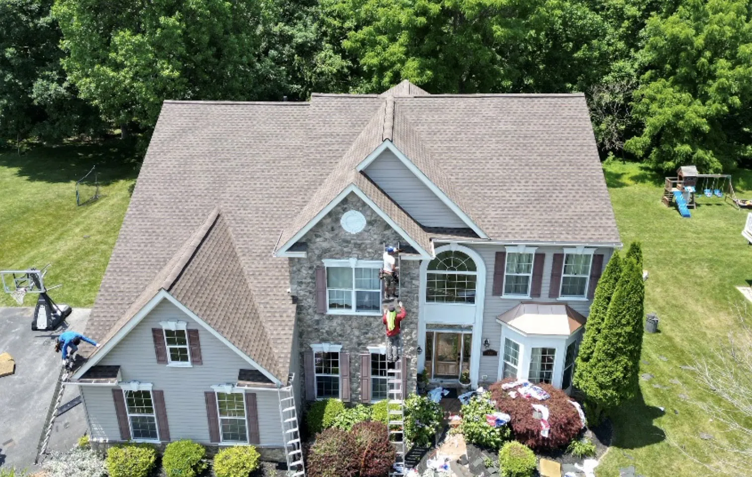 Completed roof replacement on a stone-front two-story home