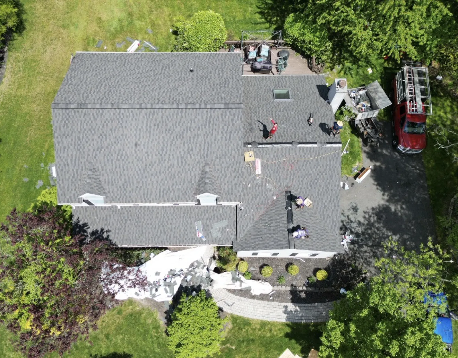 Roof tear-off in progress with a dumpster on site
