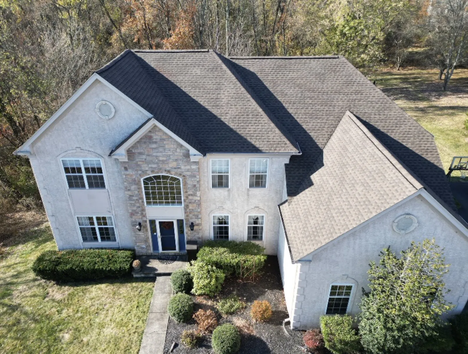 New charcoal architectural shingle roof on a stone colonial